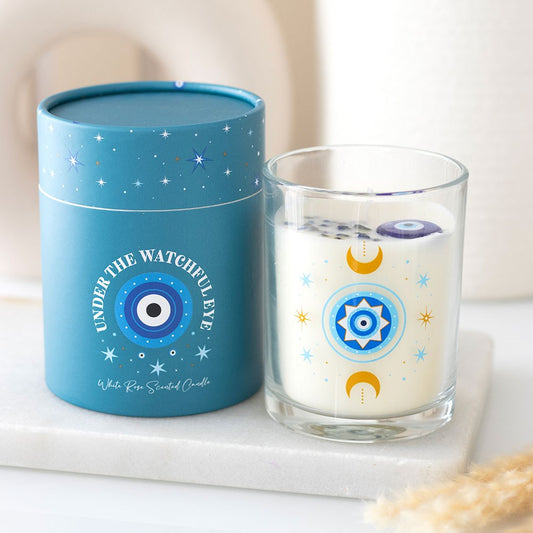Blue candle container and glass candle with star and moon design on a white surface